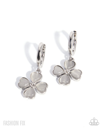 Flower-shaped earrings with silver and white accents on a white background
