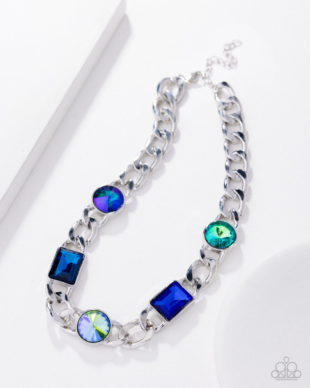 Silver chain bracelet with blue and green gemstones on a white background