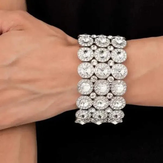 Elegant silver bracelet with large crystals on a wrist against a black background