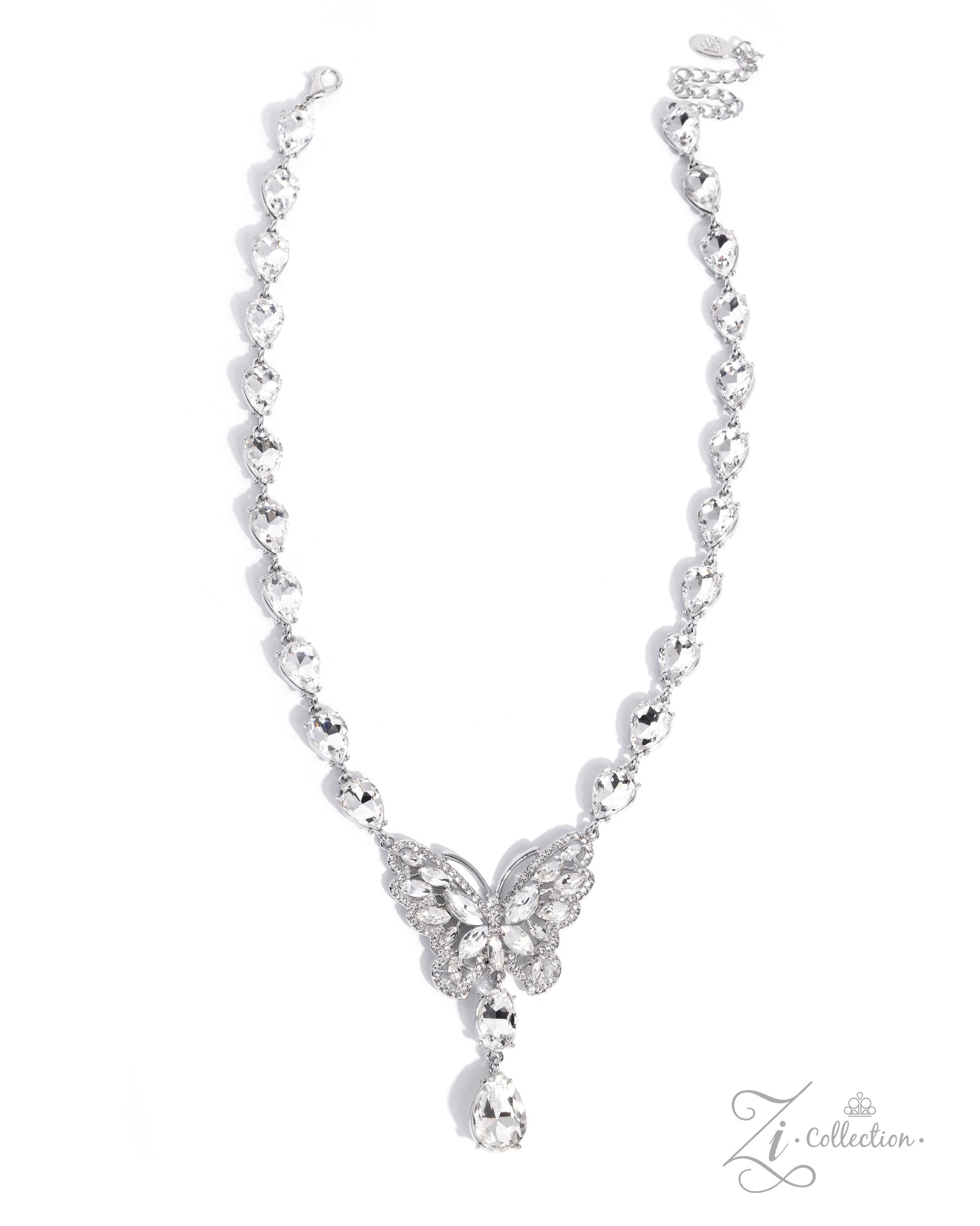 A silver-toned necklace featuring a delicate chain with small heart-shaped links, a butterfly motif paved with clear stones at the center, and a teardrop-shaped clear stone hanging from the bottom, shown on a white background with a Zi Collection logo in the corner.