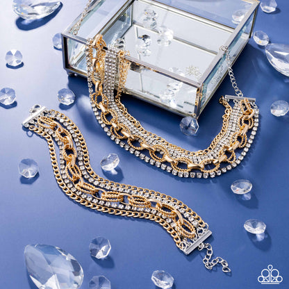 Gold and silver jewelry set with a decorative box on a blue background