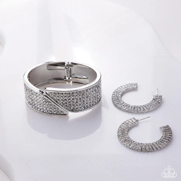 Silver bracelet and hoop earrings on a white background