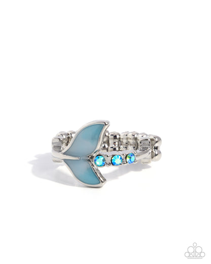 Silver ring with blue fish design and gemstones on a white background