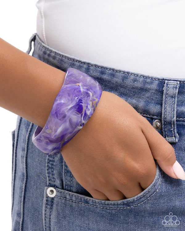 Purple marbled bracelet on a wrist with a white background