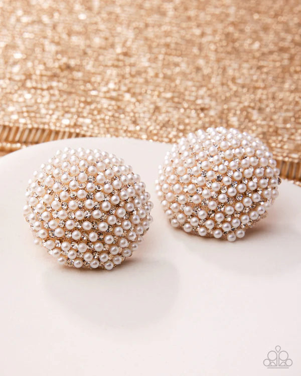 Pair of pearl earrings on a glittery background