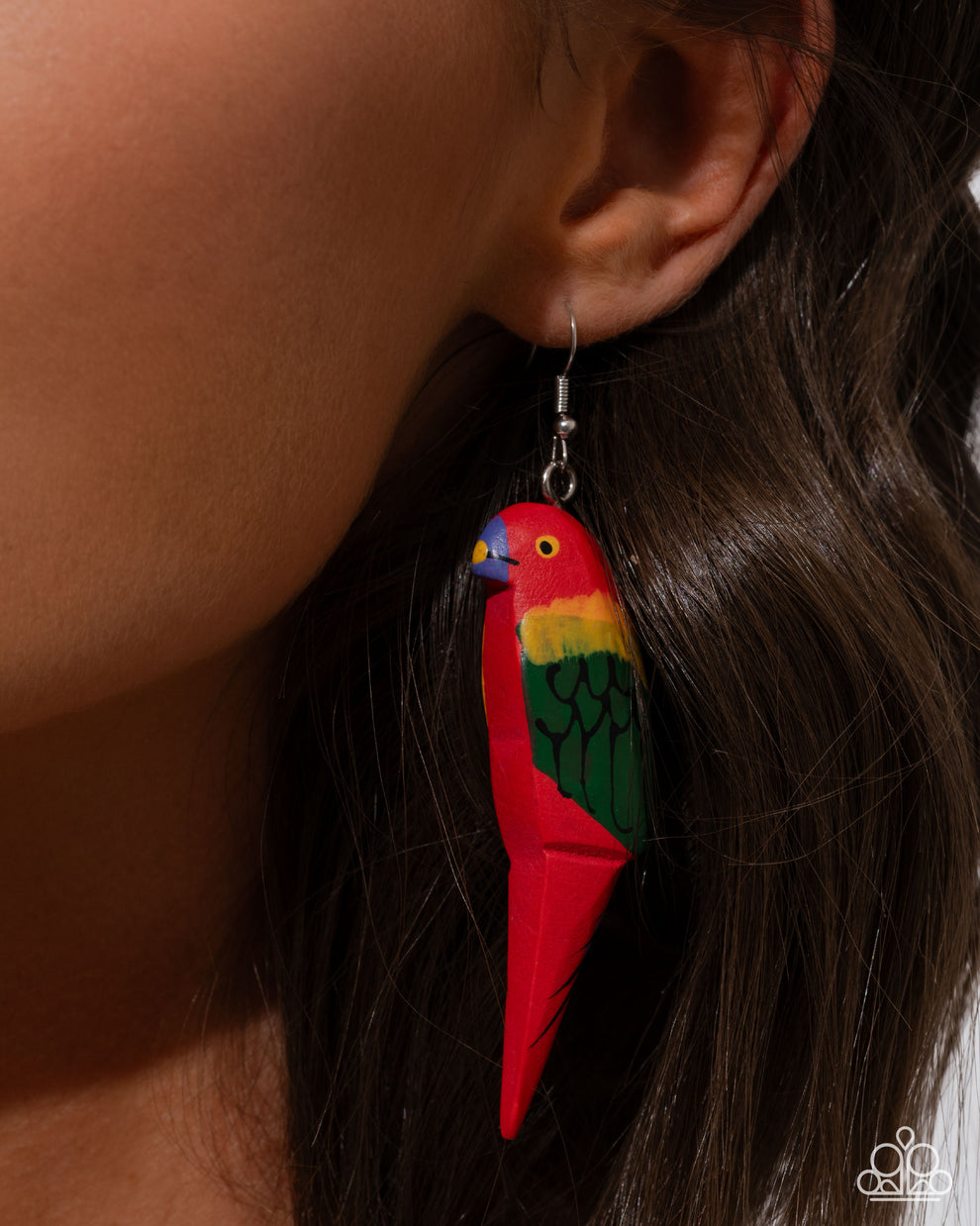 Colorful parrot-shaped earrings worn by a person with dark hair.