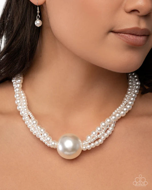Pearl necklace and earrings on a model with a neutral background