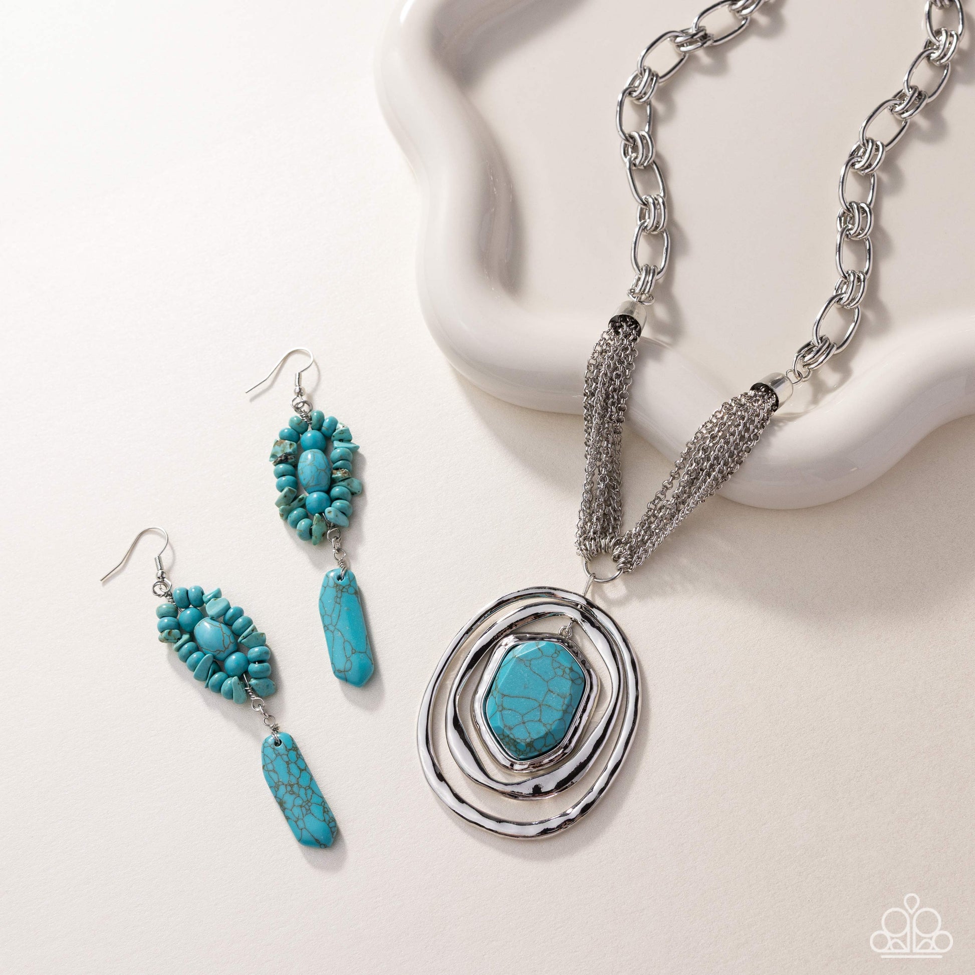 Jewelry set with turquoise stones and silver chain on a white background