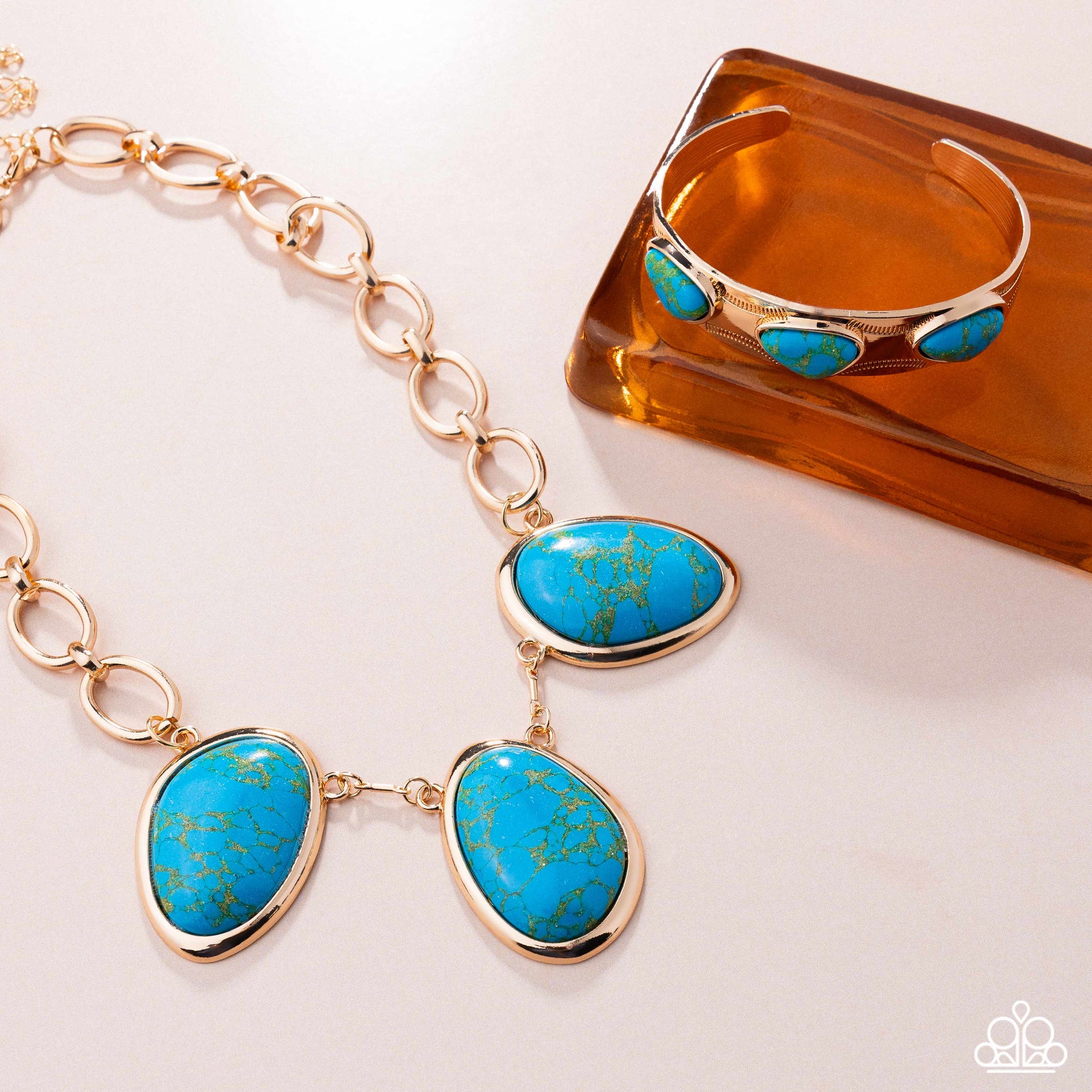 Jewelry set with turquoise stones and gold accents on a white background