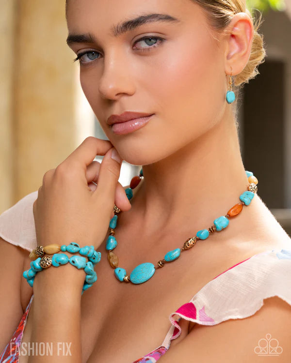 Woman wearing a turquoise beaded necklace and earrings with a blurred background