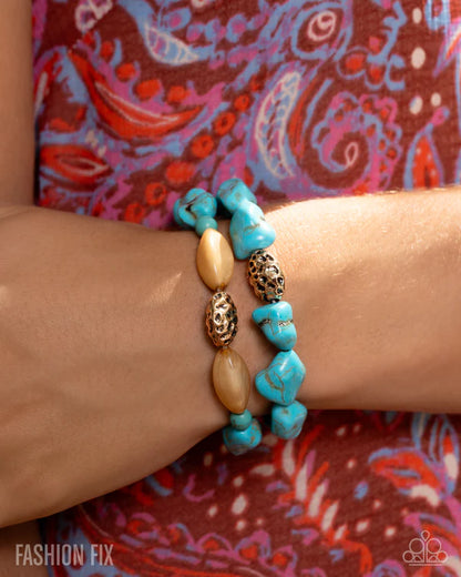 Turquoise beaded bracelet on a wrist with a colorful patterned background