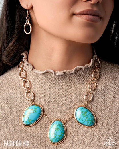 Necklace with turquoise stones and gold chain on a person wearing a beige sweater.