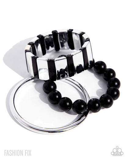 Silver and black bracelet set on a white background
