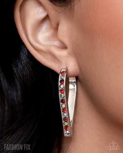 Silver hoop earring with colorful stones worn by a person