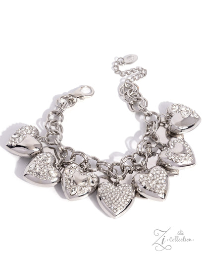 A silver-tone charm bracelet featuring multiple heart-shaped charms, some adorned with clear rhinestones, displayed on a clean white background.