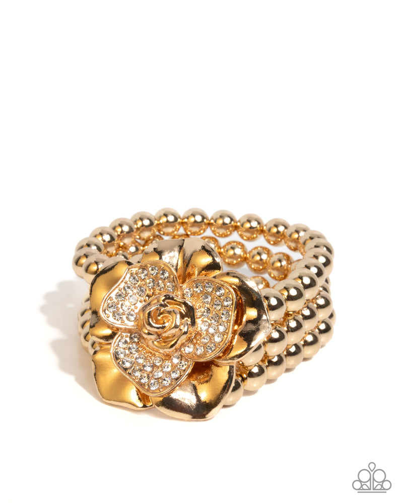 Gold bracelet with floral design on a white background