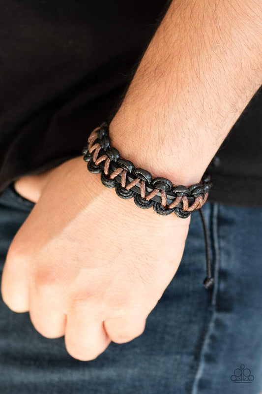 brown and black cording ornately weave around black leather cords
